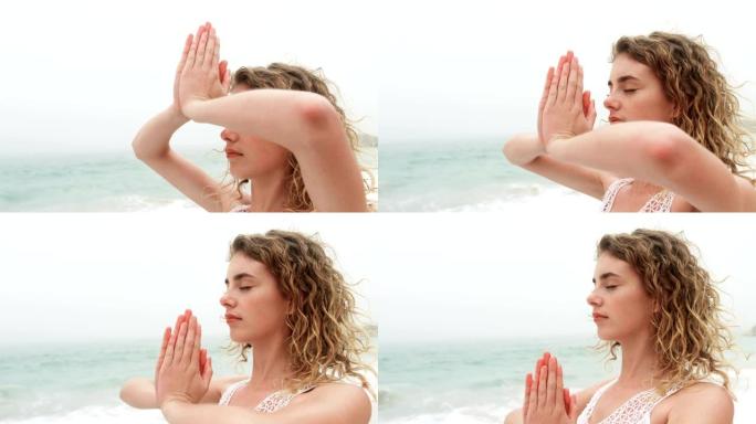 白人妇女在海滩上表演瑜伽的侧视图4k