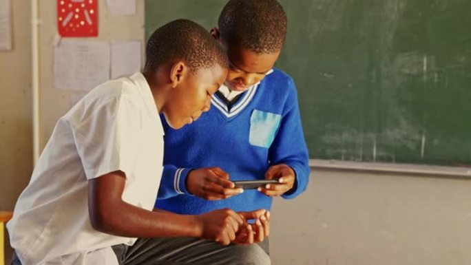 小学生在乡镇学校4k休息时使用智能手机