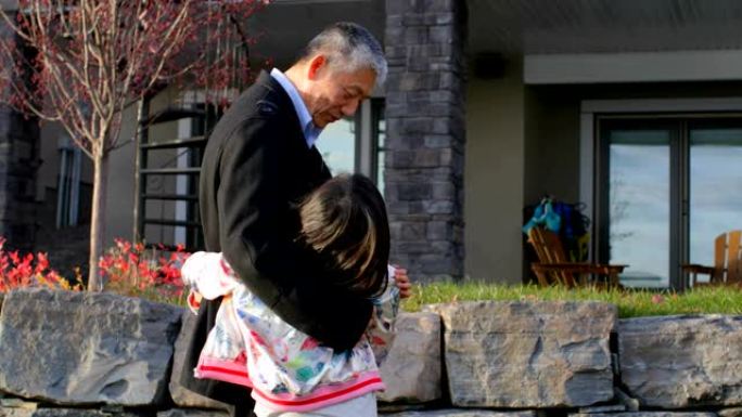 亚洲老祖父在4k屋外拥抱孙女的前视图