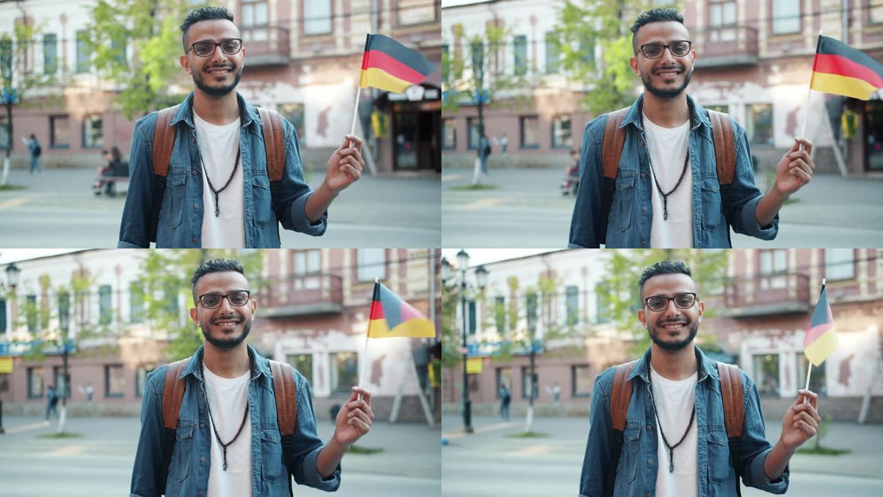 举着德国国旗在户外微笑的中东游客慢动作