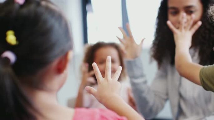 幼儿和老师在课堂上举手计数的特写镜头，有选择的重点