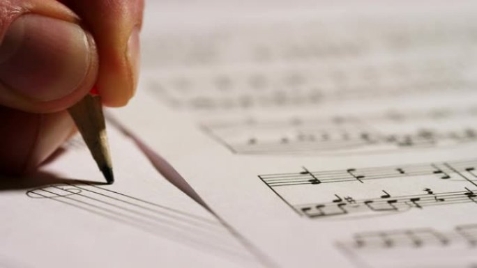 音乐家作曲家在空的五角星上写下他的新歌或歌剧的音符。这位音乐家创作他的新音乐。