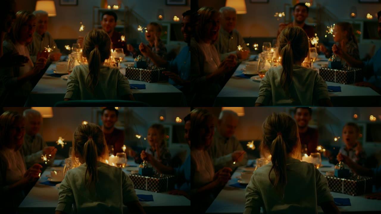 背面照片: 餐桌上可爱的小女孩在蛋糕上吹蜡烛的生日庆祝活动。在餐桌上，快乐的亲戚和朋友聚集在一起庆祝