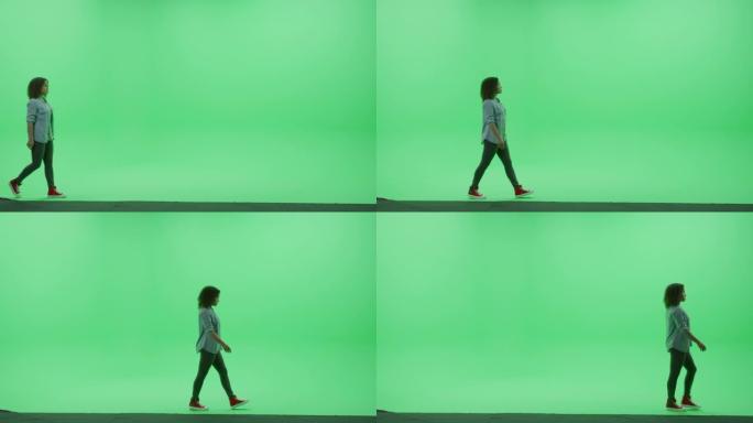 绿屏色度钥匙工作室: 穿着时尚休闲服的美丽年轻少女从左到右穿过房间。侧视图摄像机拍摄