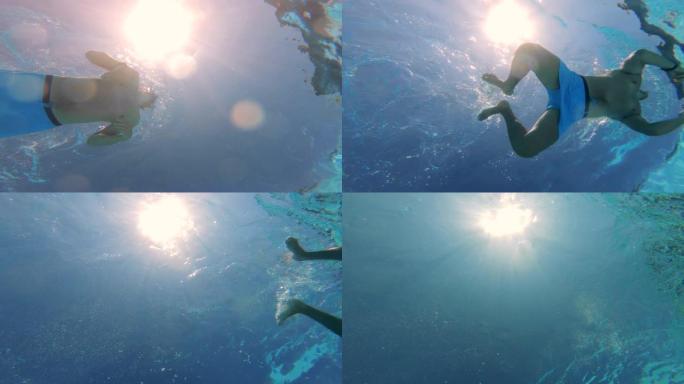 阳光和水下游泳的人