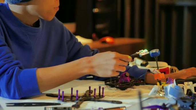 一个人在机器人俱乐部项目的全功能可编程机器人上工作。创意设计师在车间测试机器人原型。创新，科学概念