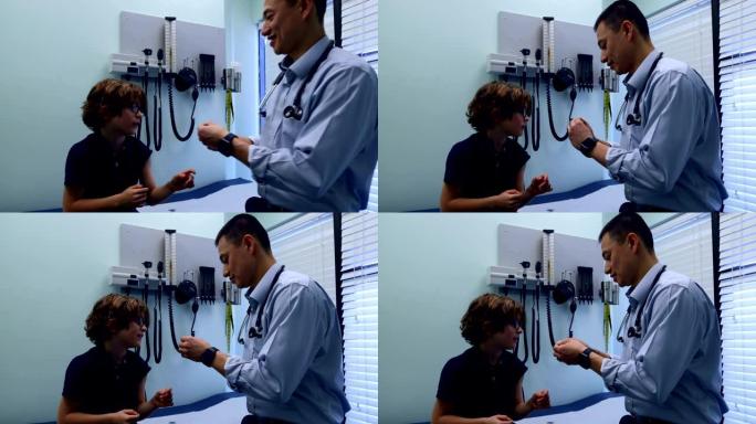 年轻的亚洲男性医生在诊所4k对高加索男孩患者手臂使用创可贴的侧视图