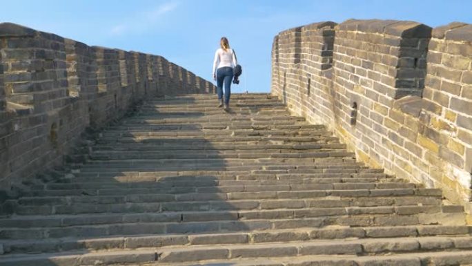 低角度: 女人在中国长城的顶部走上楼梯。