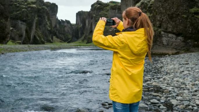 游客在雨天拍摄冰岛峡谷Fjadrargljufur