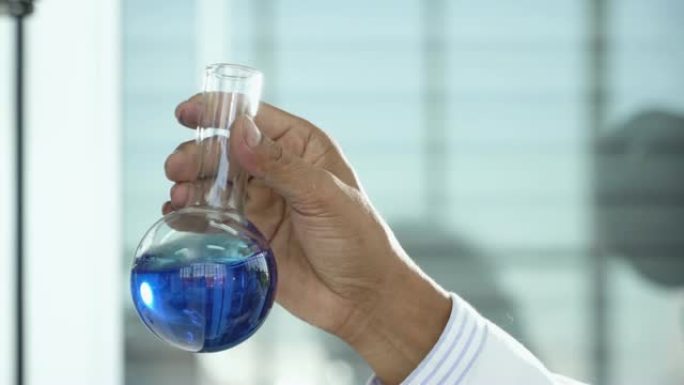 4k: 科学家在实验室的烧杯中摇动液体。