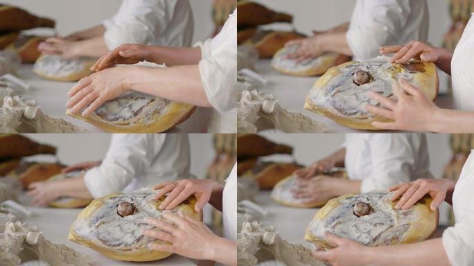 正如意大利古代传统所教导的那样，在调味之前，用脂肪收集火腿的手的特写镜头，以赋予风味并保护霉菌。