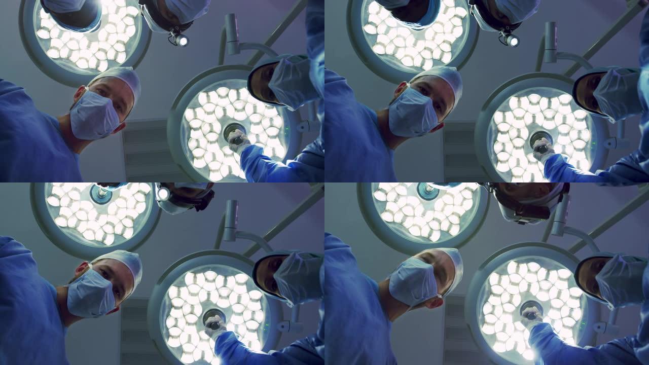 在医院手术室进行手术的多民族外科医生的向上视图