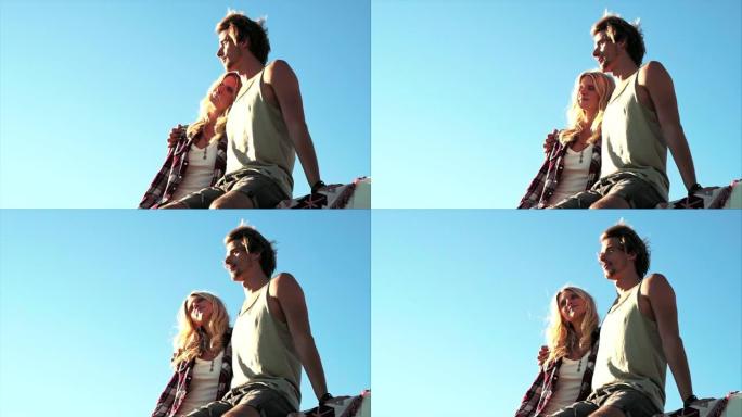 晴天坐在货车屋顶上的夫妇