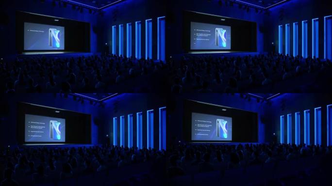 新产品发布的现场活动: Keynote智能手机设备向充满技术参与者的礼堂展示。电影院屏幕显示具有高端
