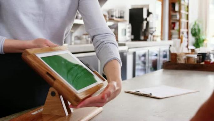 客户在咖啡店柜台用智能手机付款
