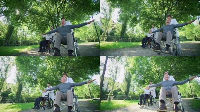 无忧无虑快乐的社会工作者和老年夫妇坐在轮椅上的慢动作，在阳光明媚的日子里在绿色公园里玩耍