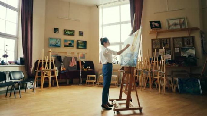 创意女孩专注于用调色板和画笔站在画架前的油画和油画绘画海洋景观。