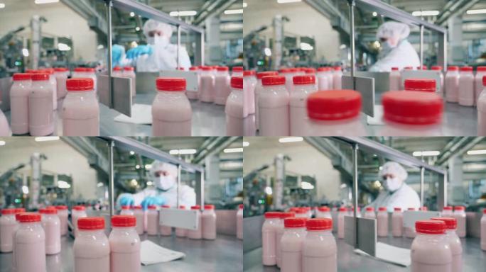 人在工厂用酸奶瓶工作。