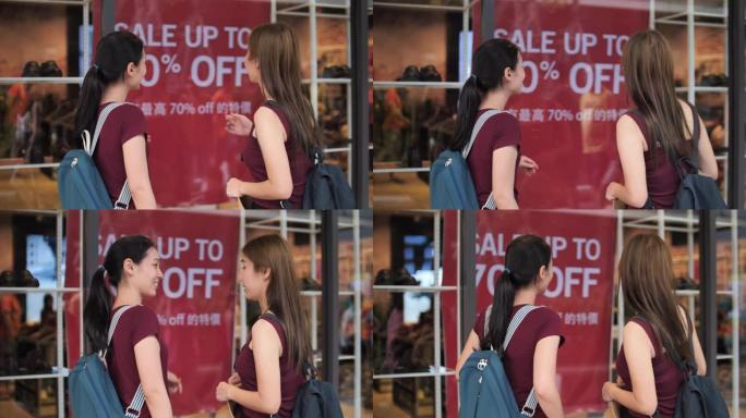 妇女和朋友一起聊天，在商店橱窗里寻找销售