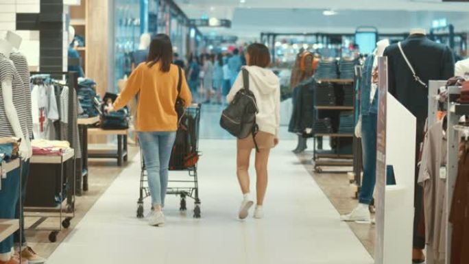 两名年轻妇女在百货商店购物，慢动作