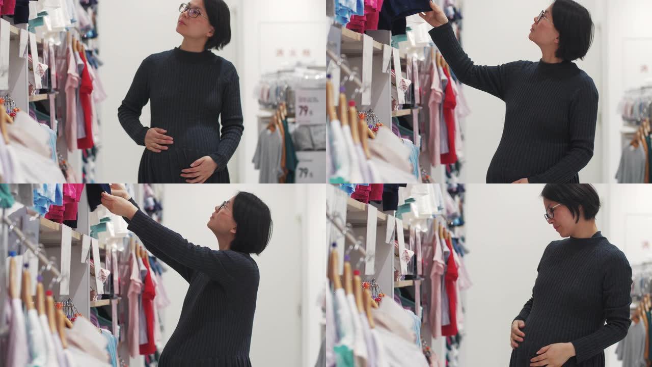 怀孕亚洲妇女在服装店购物