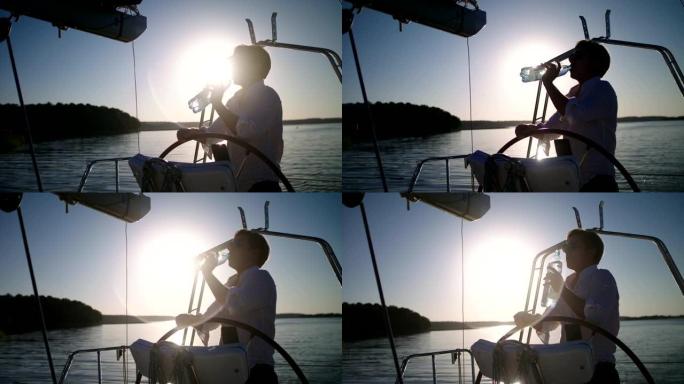 湖上的日落。享受帆船运动的年轻人