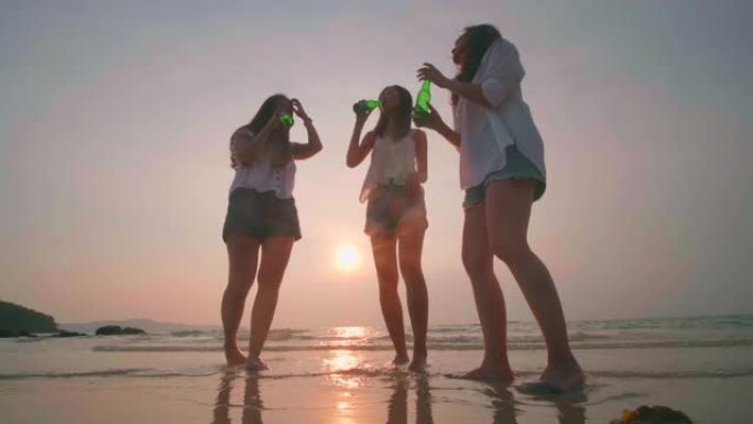 一群年轻女子在日落时在海滩上跳舞