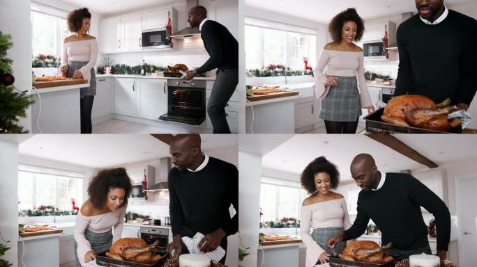年轻的黑人夫妇在家里一起准备圣诞晚餐，男人从烤箱里拿出烤火鸡，夫妇一起吃烤火鸡，特写镜头