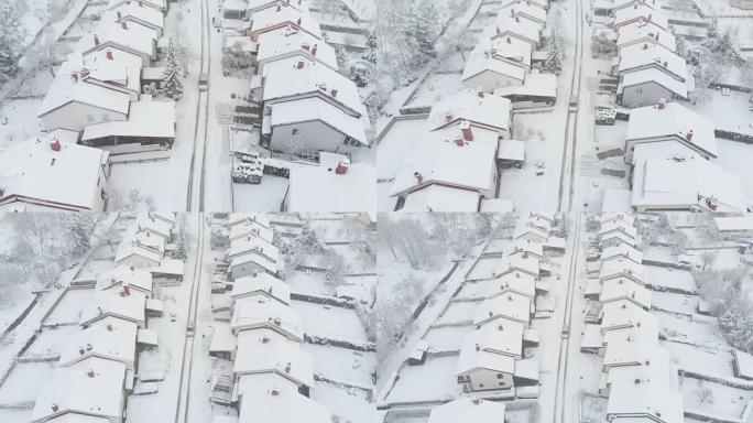 空中: 汽车驶过雪谷郊区，经过积雪覆盖的排屋