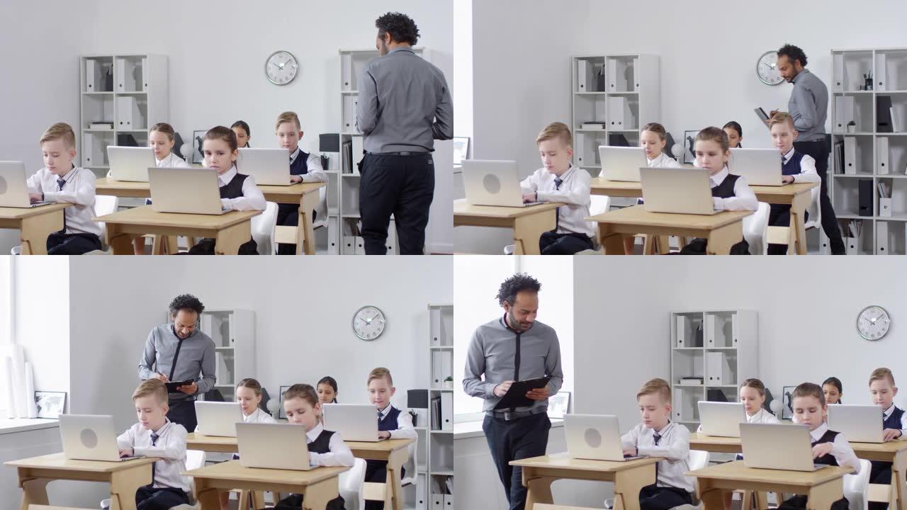 黑人男老师在计算机扫盲课上检查学生