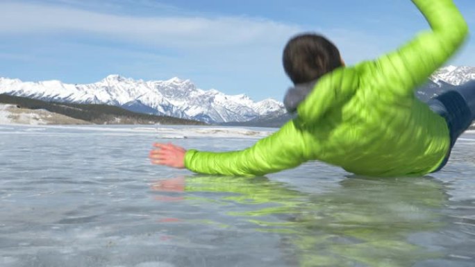 低角度: 无法辨认的人沿着冰冻的亚伯拉罕湖行走滑倒。