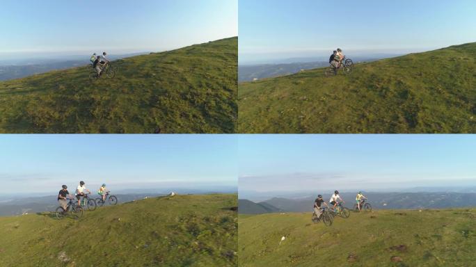 空中: 在一个阳光明媚的下午，朋友们在草木山上骑电动自行车。