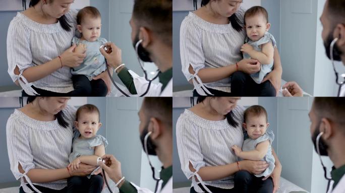 男性儿科医生在医疗预约中检查女婴的心脏
