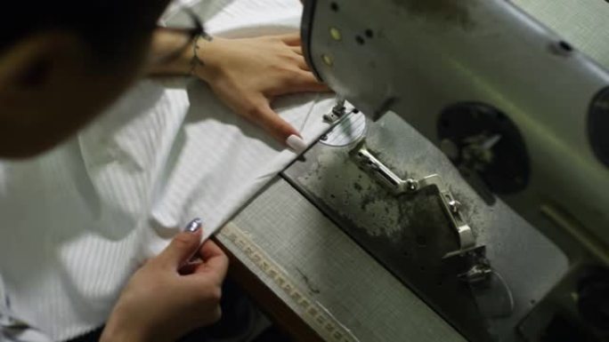 女人用缝纫机缝线俯拍视角细致认真小作坊店