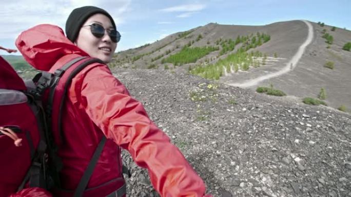 徒步旅行时与男朋友牵手的快乐亚洲女人的视点