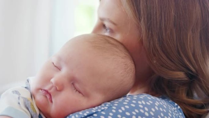 安静的男婴在母亲的肩膀上睡觉的特写镜头-慢动作