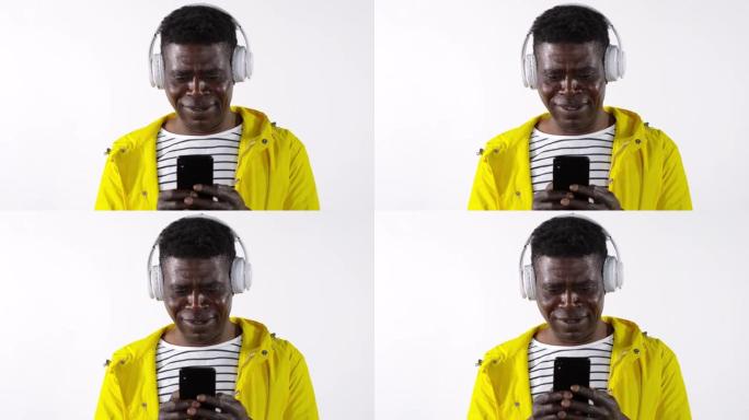 戴着耳机的非洲男子使用智能手机