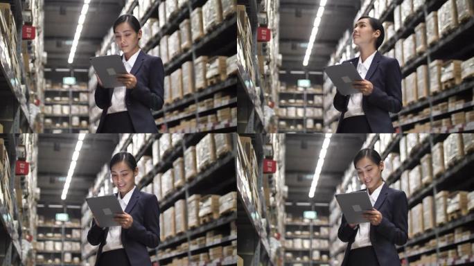 亚洲女商人在工厂仓库的数字平板电脑上检查库存。