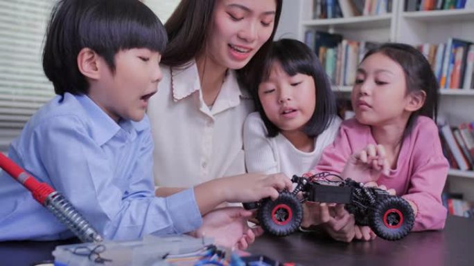 老师在stem教育课上帮助她的学生使用diy机器人。快乐的孩子在课外课上学习编程。教育，儿童，技术，
