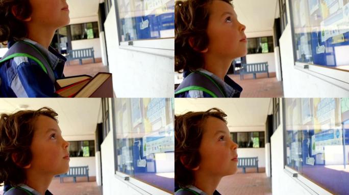 高加索男生在学校走廊4k看布告板的侧视图