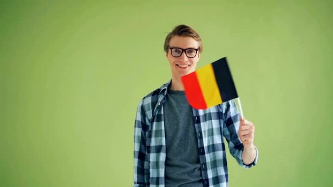 年轻男子微笑着挥舞德国国旗的慢动作肖像