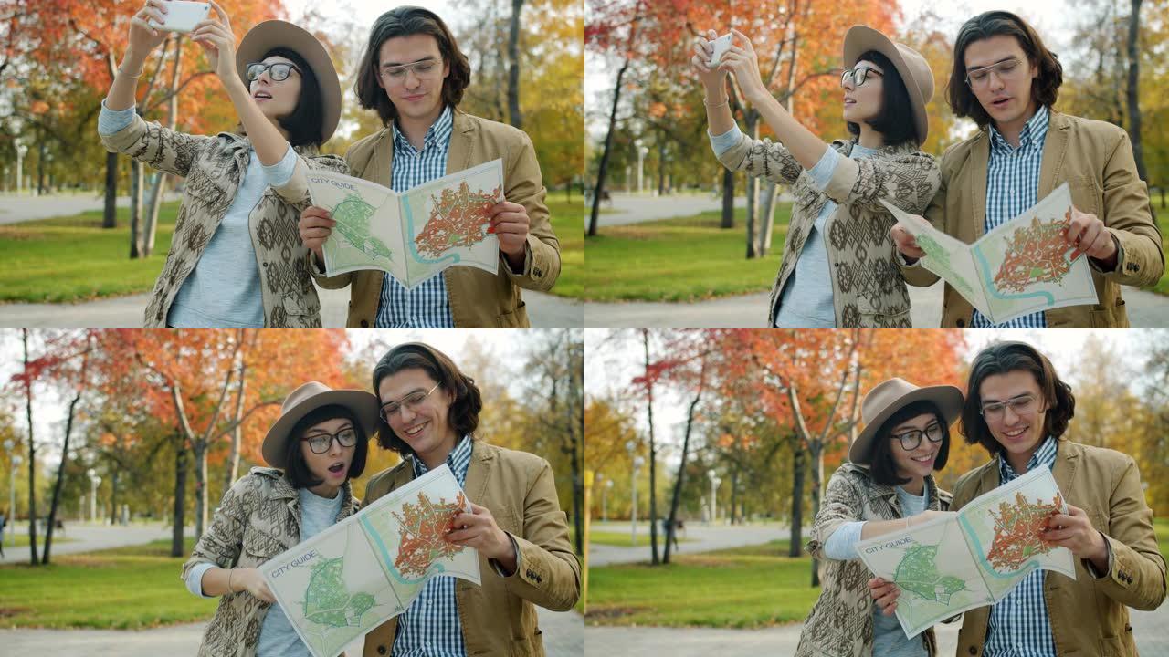 游客男人和女人在户外看地图并用智能手机拍照