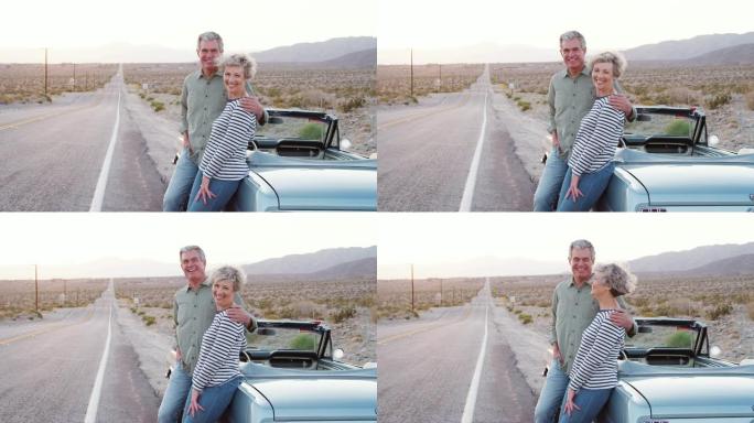 公路旅行中的高级夫妇站在汽车旁对着镜头微笑