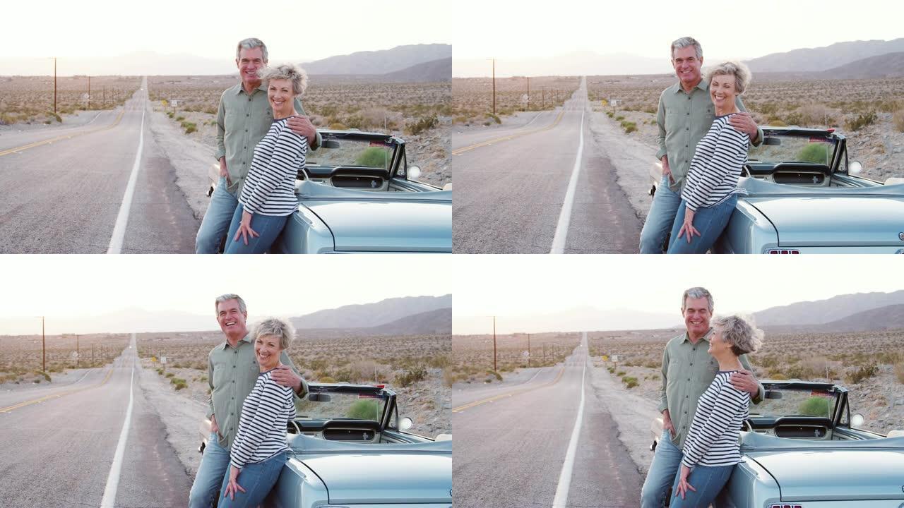 公路旅行中的高级夫妇站在汽车旁对着镜头微笑