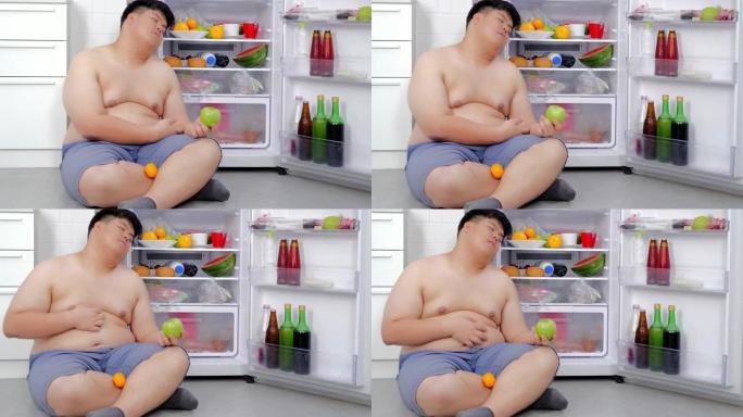 超重的人打开冰箱，吃晚饭，坐在冰箱前睡觉。真实的身体