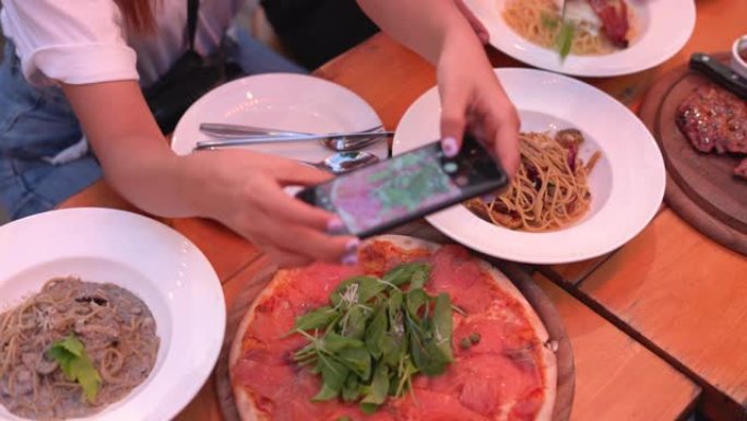 女人用手机给食物拍照