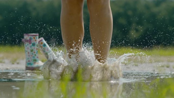 SLO MO赤脚女人在泥泞的水坑中大放异彩