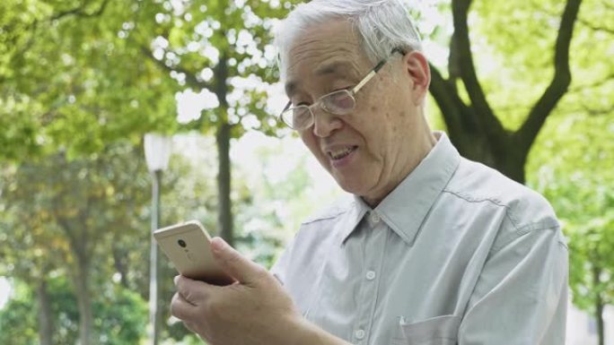 中国高级男子在公园使用智能手机