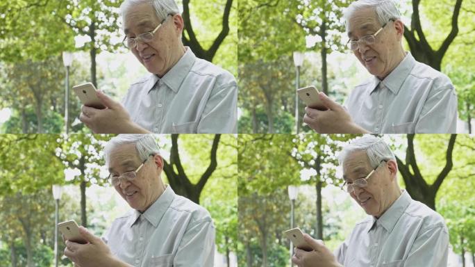 中国高级男子在公园使用智能手机