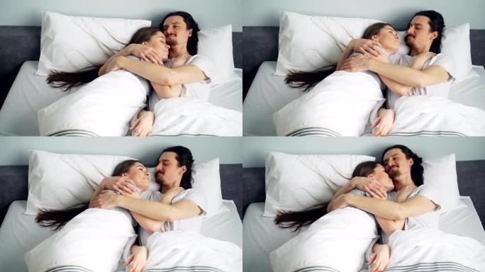 男女夫妇躺在床上，拥抱着享受就寝时间